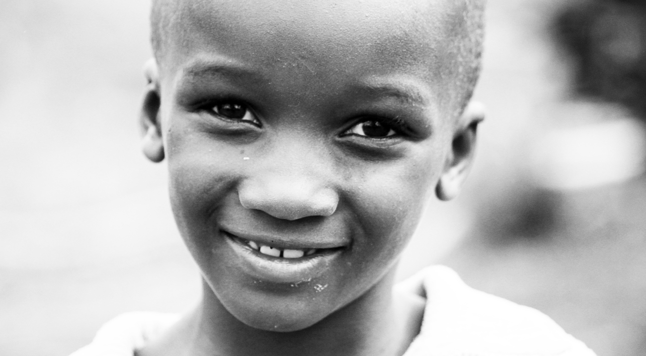 Black-and-white close-up of a young child smiling